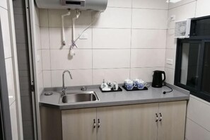 A kitchen with a sink, cabinets, and a window. - Jingshe Hostel (Guilin)