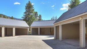 En bygning med tre tilhørende garager, hver med et metal tag og åbne garageporte.