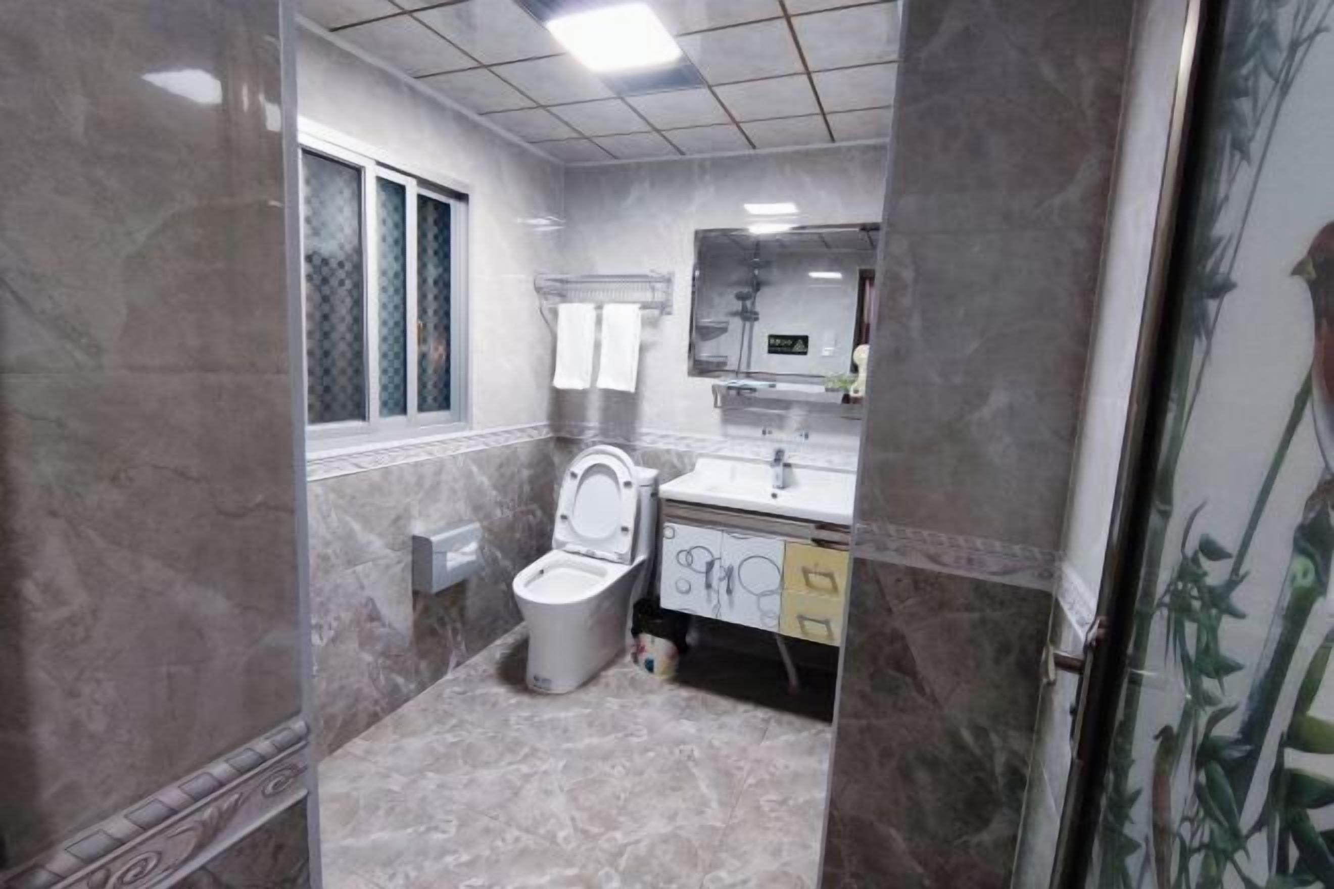 A bathroom with a toilet, sink, and mirror.