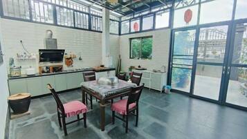 Una cocina con comedor, televisión y un amplio ventanal.