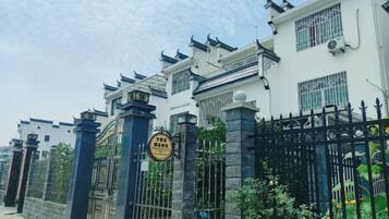 A gated residential area with traditional architectural elements, including tiled roofs and decorative eaves.