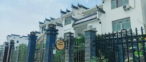 A gated residential area with traditional architectural elements, including tiled roofs and decorative eaves.