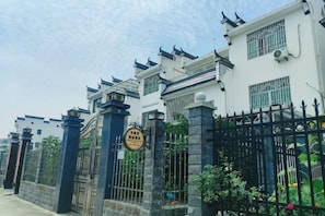 A gated residential area with traditional architectural elements, including tiled roofs and decorative eaves. - Shuijutang Boutique Inn (Wuyuan)