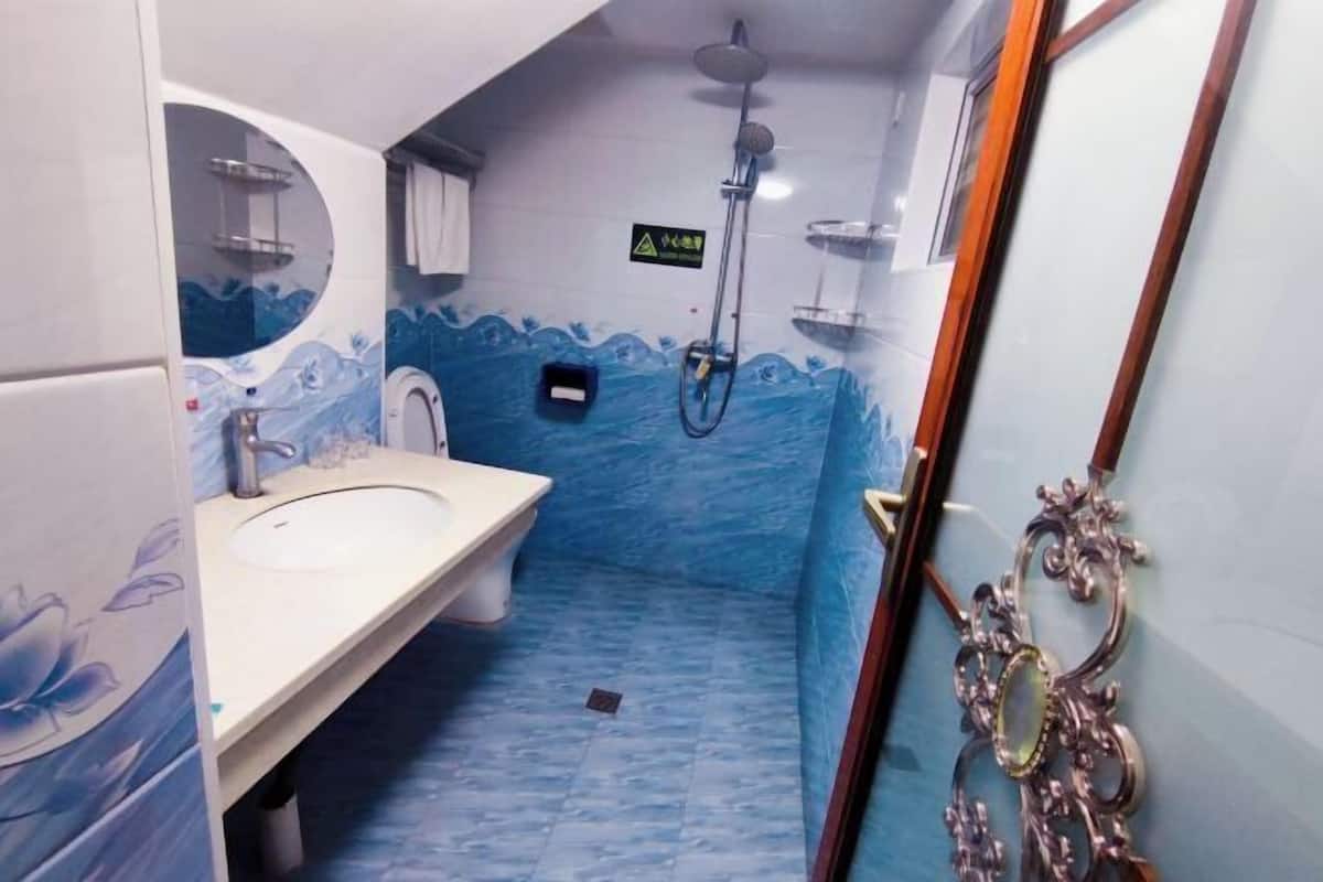 A bathroom with a sink, toilet, and shower area.