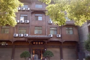 Un bâtiment traditionnel doté de plusieurs unités de climatisation, d’une façade en bois et d’une enseigne au-dessus de l’entrée.