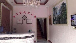 A reception area with a marble counter, a chandelier, framed certificates, and a staircase leading to another floor. - Yijia Inn (Chongqing)