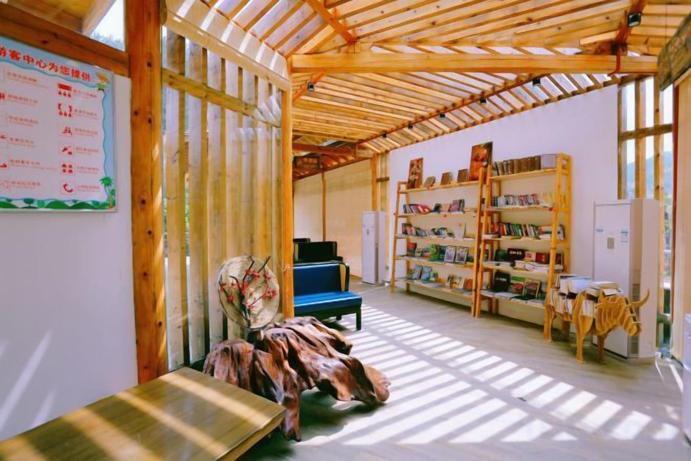 Una habitación con techo de madera, una silla azul, una mesa de madera y una estantería.