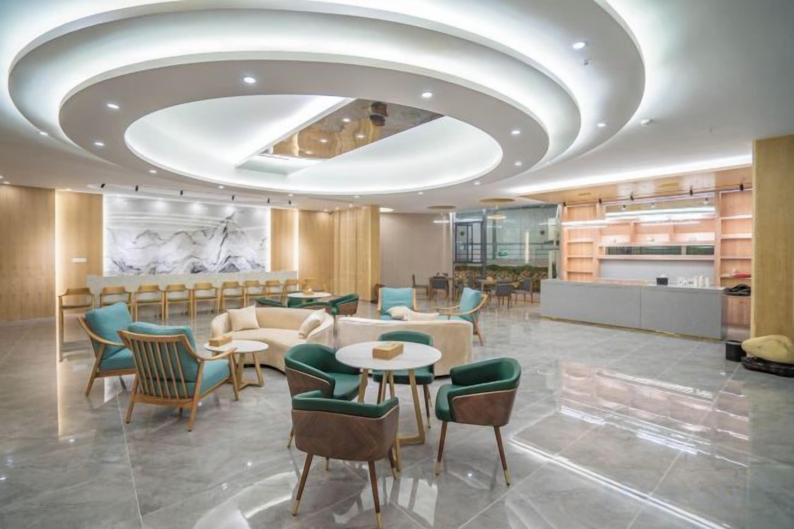 A modern lobby with a seating area, a reception desk, and a marble wall.