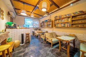 Eine gemütliche Bibliothek mit Bücherregalen, einer Kaffeebar und bequemen Sitzbereichen.