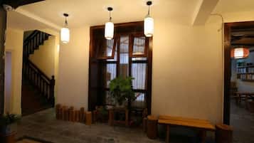 A wooden staircase leading to a room with a bench and a potted plant.