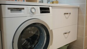 A front view of a Bosch washing machine with a control panel, a front-loading door, and a white exterior. - Beautiful apartment 50m from the marina (Saint-Valery-sur-Somme)