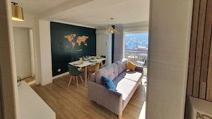 Ein moderner Wohnraum mit Essbereich, einer Couch und Blick auf die Stadt.