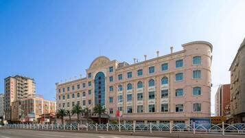 Un hotel de varios pisos con fachada curva, ventanas grandes y una entrada destacada.