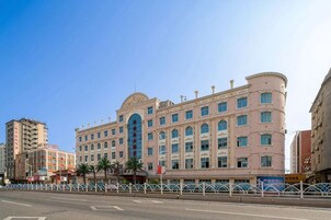 Un hotel de varios pisos con fachada curva, ventanas grandes y una entrada destacada.