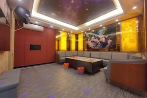 Une pièce dotée d’un plafond en retrait, d’un coin salon avec un canapé et une table, et d’une grande fresque murale.