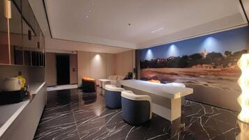 Um lobby de hotel moderno com balcão de recepção, área de estar e um grande mural na parede.
