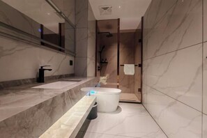 Une salle de bain moderne avec un meuble-lavabo en marbre, des toilettes et un espace douche.