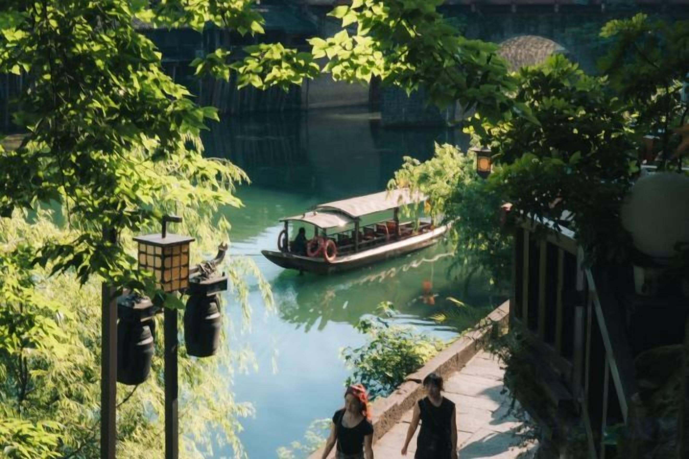 A boat on a river, surrounded by greenery and a stone pathway.