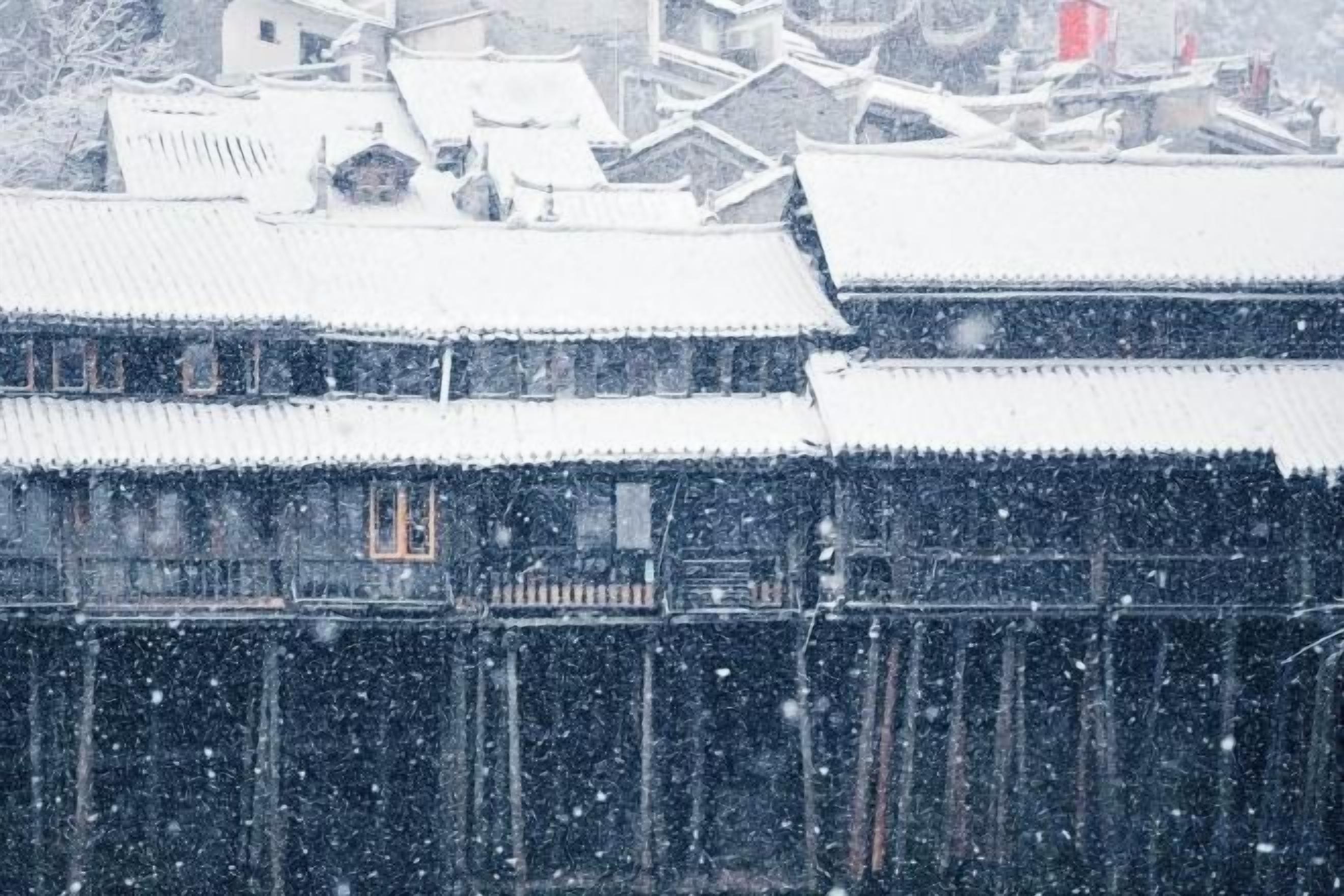 A traditional building with multiple levels and a snow-covered roof.