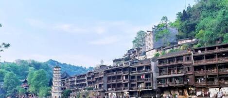 A riverside town with traditional architecture, including multi-story buildings and a pagoda.