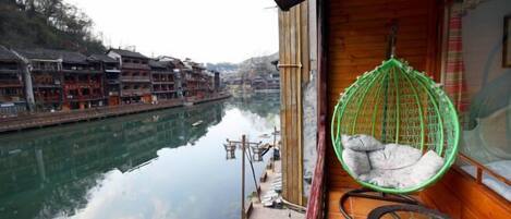 A wooden building with a view of a river and traditional buildings.