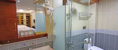 A bathroom with a glass-enclosed shower, a white sink, and a toilet.