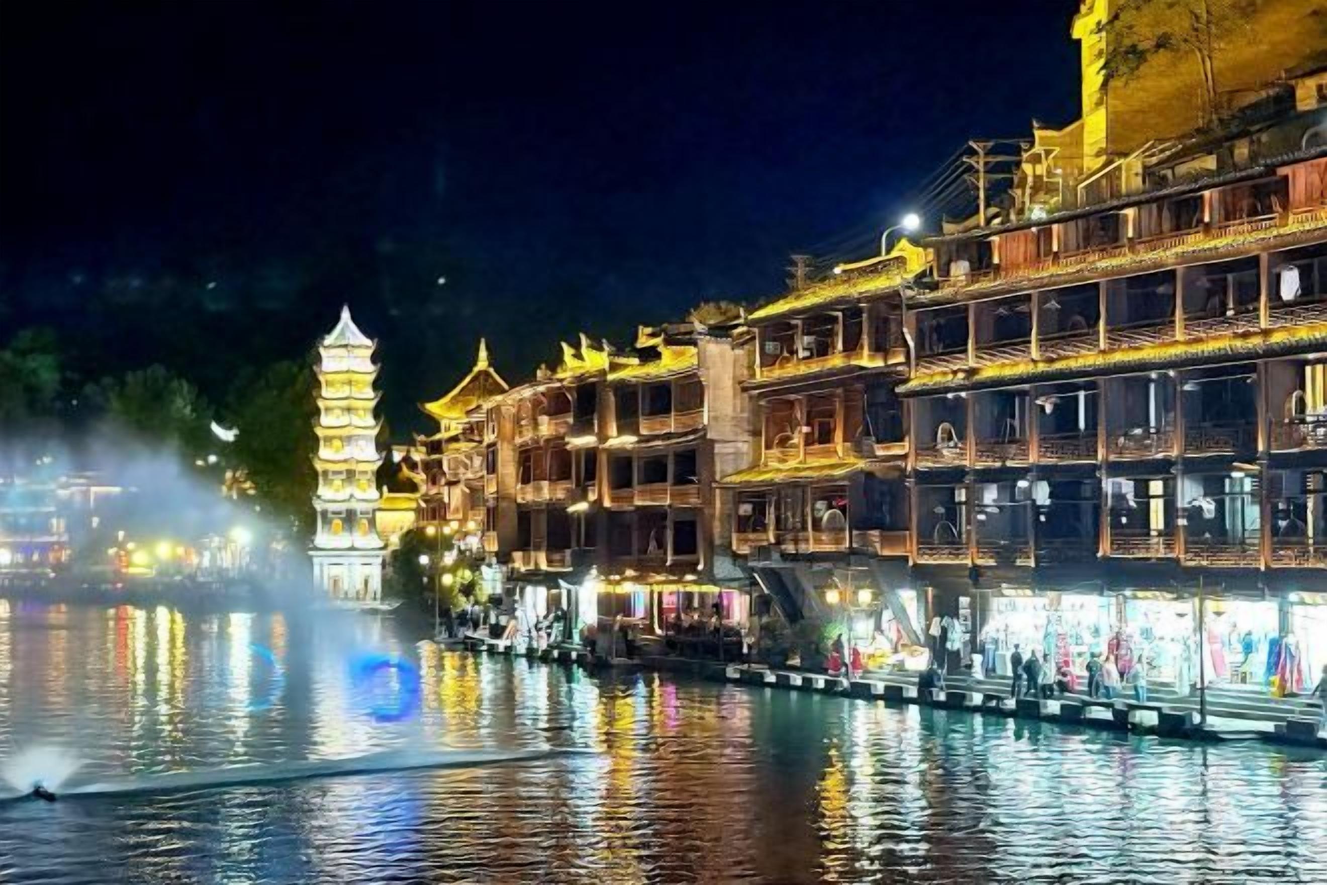A traditional building with multiple levels and balconies, adjacent to a body of water with a reflection.