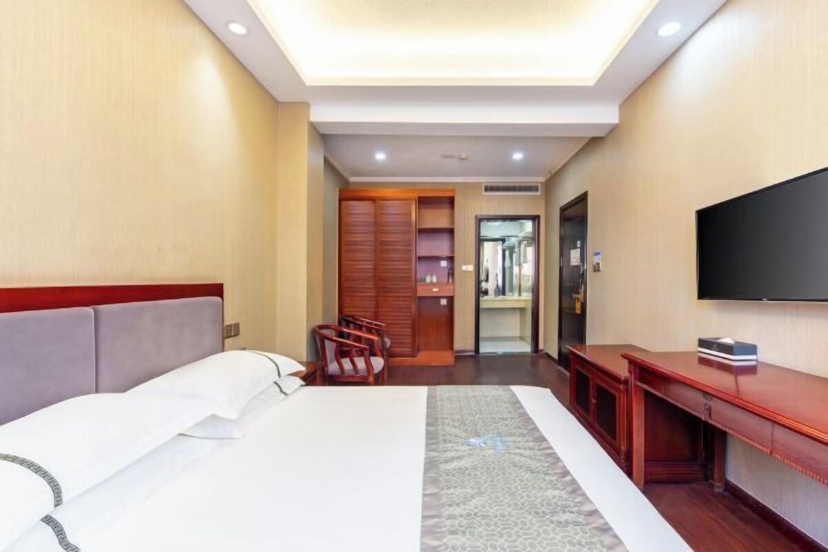 Une chambre d’hôtel équipée d’un lit, d’une télévision, d’un bureau et d’une armoire.