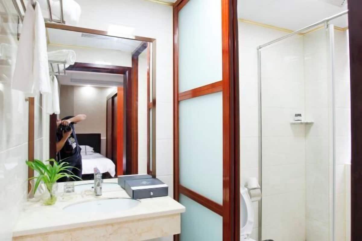Une salle de bain équipée d’un miroir, d’un lavabo, d’un porte-serviettes et d’une douche.