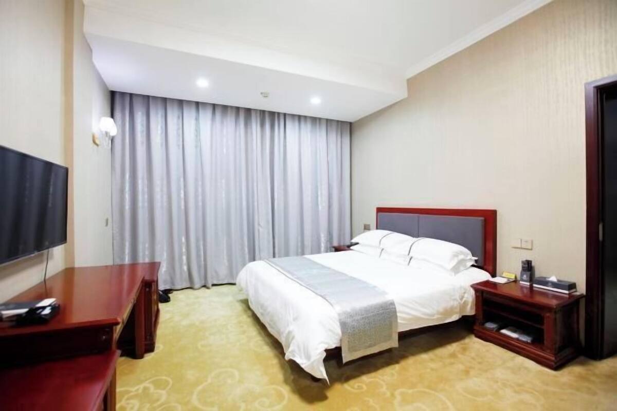 Une chambre d’hôtel équipée d’un lit, d’une télévision, d’un bureau et d’une table de chevet.