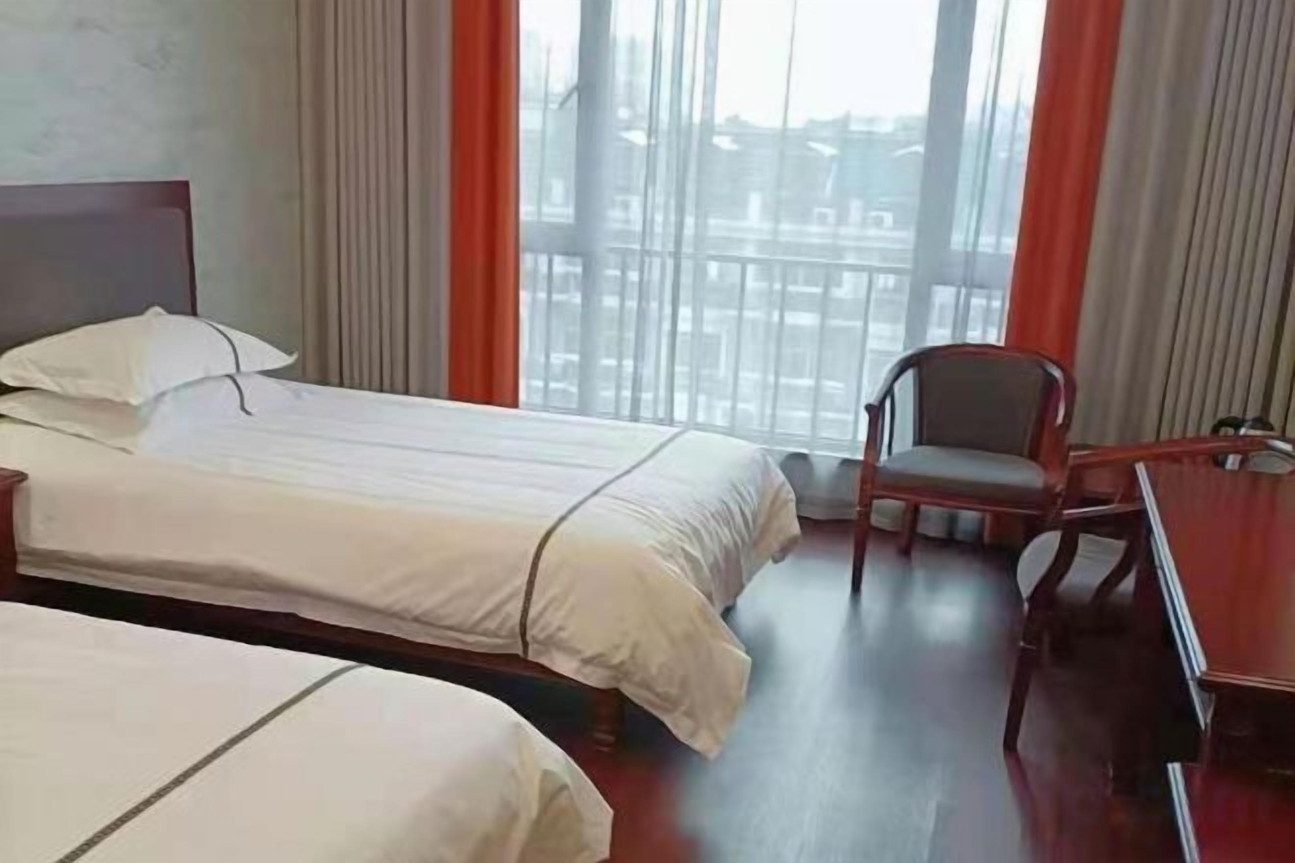 Una habitación de hotel con dos camas, un escritorio y una silla.