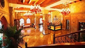 Eine geräumige Lobby mit hoher Decke, Kronleuchtern und einer Rezeption.