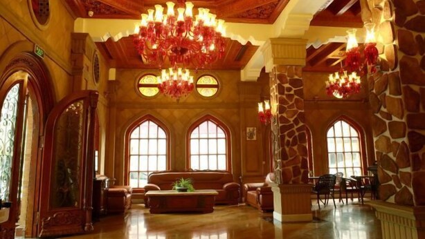 Eine geräumige Lobby mit hoher Decke, großen Kronleuchtern und Rundbogenfenstern.