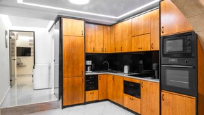 Een moderne keuken met houten kastjes, een ingebouwde magnetron en een dubbele oven.