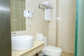 A bathroom with a sink, toilet, and a hairdryer on the wall. - Shangjia Hotel (Anping)