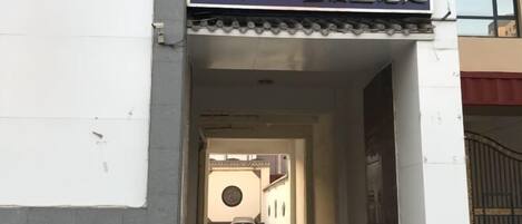 A hotel entrance with a sign indicating a guest registration area.
