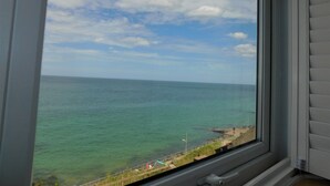Vista dell'oceano attraverso una finestra, cielo sereno con poche nuvole.