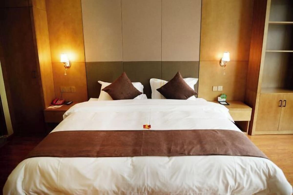 Ein Hotelzimmer mit einem großen Bett, zwei Nachttischen und einem Kleiderschrank.