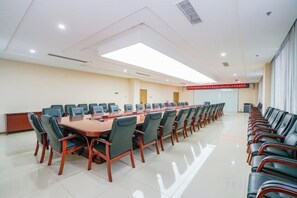 A conference room with a long table and chairs, a podium, and a red sign on the wall. - Huangyang Hotel (Nanjiang Dejian) (Nanjiang)