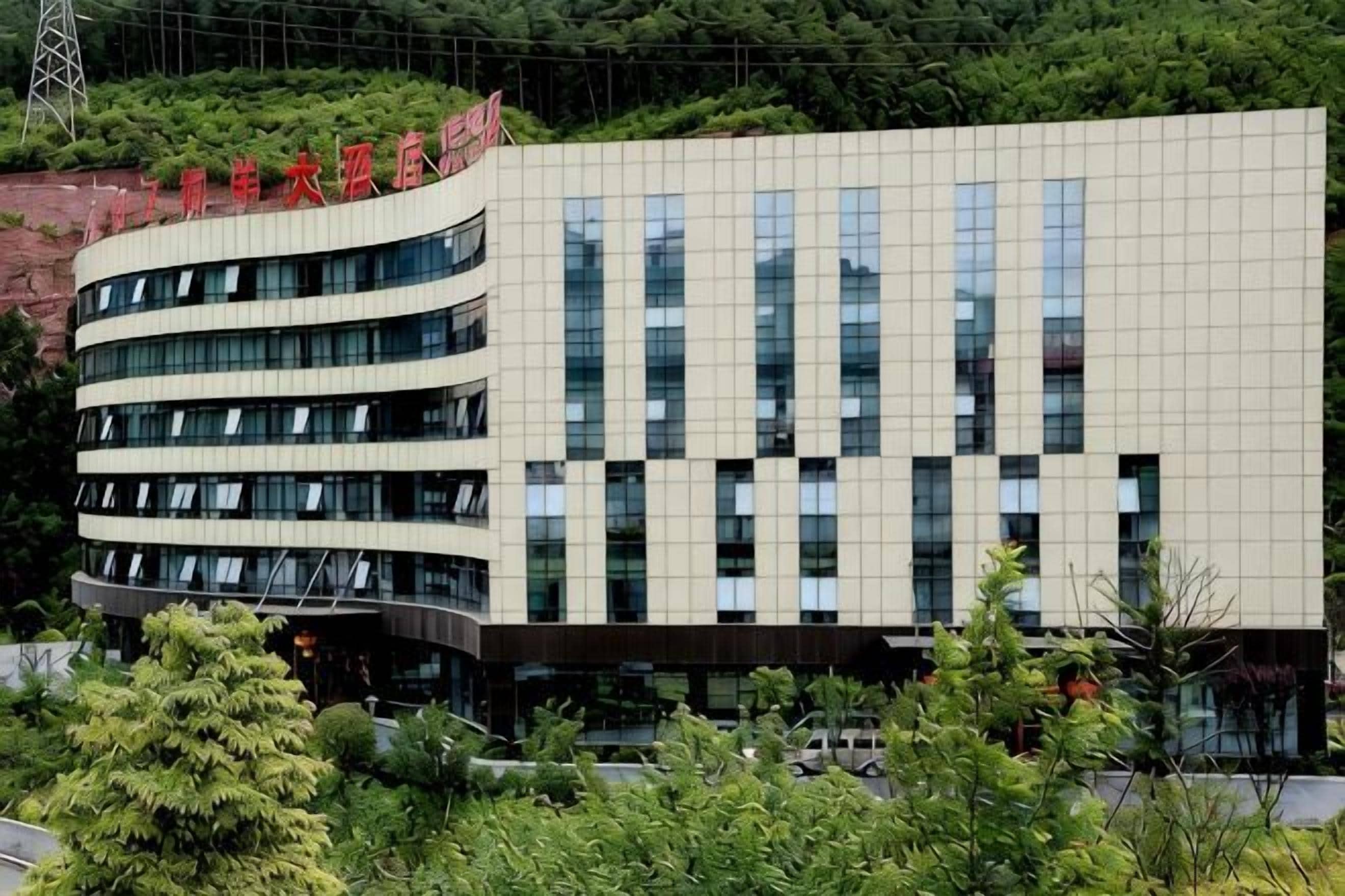 A multi-story building with a modern architectural design, featuring a series of windows and a flat roof.