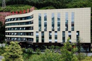 A multi-story building with a modern architectural design, featuring a series of windows and a flat roof.