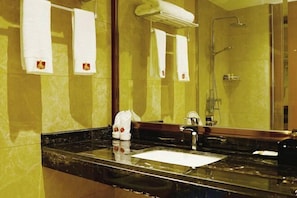 A bathroom with a marble countertop, a sink, a mirror, and a shower. - Huangyang Hotel (Nanjiang Dejian) (Nanjiang)