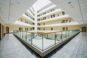 A multi-level atrium with a glass railing, marble flooring, and a skylight. - Huangyang Hotel (Nanjiang Dejian) (Nanjiang)