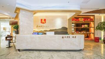 A reception desk with a logo, a counter, and a seating area with chairs.