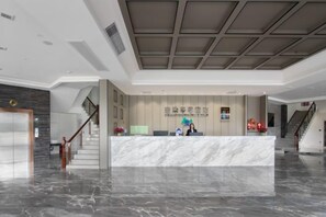 A hotel reception area with a marble counter, a staircase, and a modern ceiling design. - 1700 Hotel (Pingle)