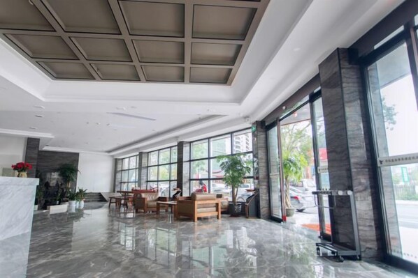 A spacious lobby with a marble floor, large windows, and a reception desk. - 1700 Hotel (Pingle)