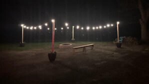 Een terras met lichtjes, een bank en plantenbakken.
