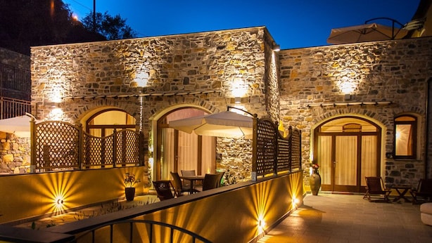 A stone building with outdoor seating and a covered patio area. - Housing with private garden terrace and residential swimming pool (Liguria)
