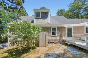 A two-story house with a covered porch, a small attached garage, and a fenced yard.