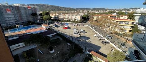 Zona residencial con piscina, aparcamiento y edificios.